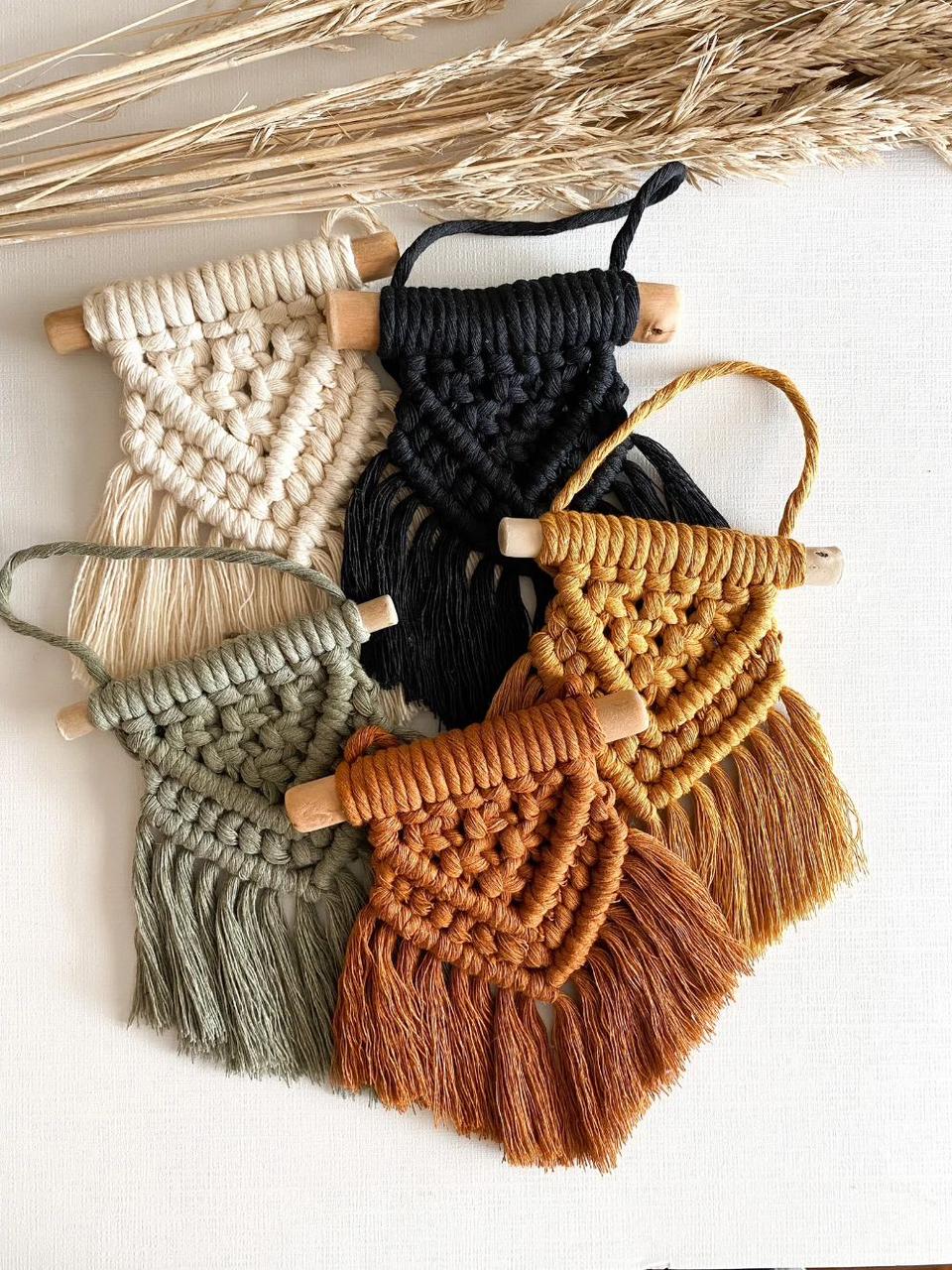 Assorted macramé wall hangings with wooden dowels